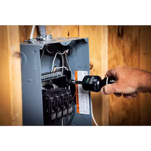 Electrician using a torque screwdriver on a breaker